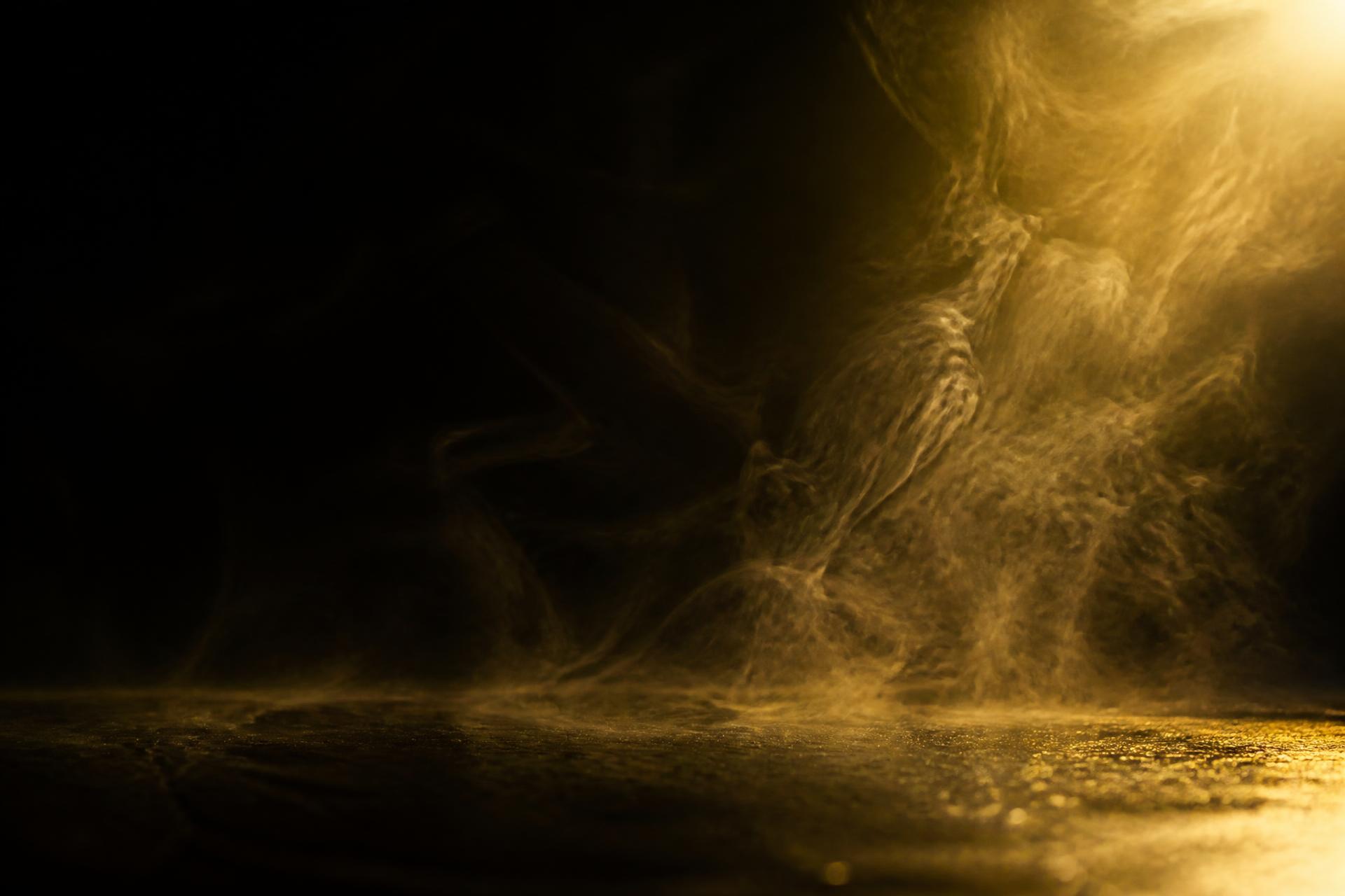 Golden light drifting through still dark air